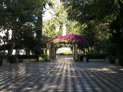 a garden with a arch with purple flowers on it at Atico Centro Historico in Cádiz