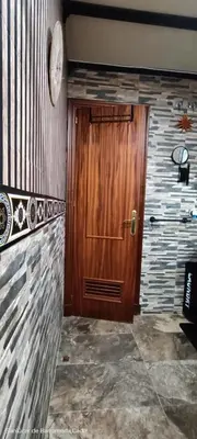 a wooden door in a room with a stone wall at La Casita Del Indio in Sanlúcar de Barrameda