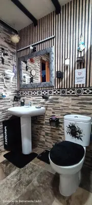 a bathroom with a toilet and a sink and a mirror at La Casita Del Indio in Sanlúcar de Barrameda