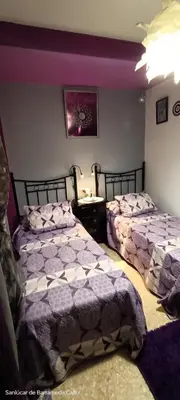 a bedroom with two beds and a table in it at La Casita Del Indio in Sanlúcar de Barrameda