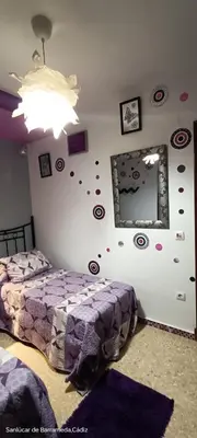 a bedroom with two beds and a wall with stickers at La Casita Del Indio in Sanlúcar de Barrameda