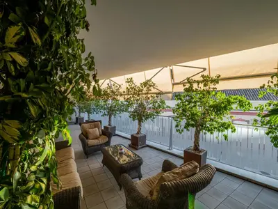 an outdoor patio with chairs and trees on a balcony at Apto Valdespino Gran Terraza fjhomefj in Jerez de la Frontera