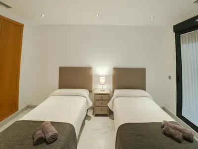 two beds in a hotel room with towels on them at Apto Valdespino Gran Terraza fjhomefj in Jerez de la Frontera