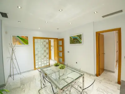 a room with a glass table and paintings on the wall at Apto Valdespino Gran Terraza fjhomefj in Jerez de la Frontera