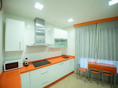 a kitchen with orange and white cabinets and a sink at Apto Valdespino Gran Terraza fjhomefj in Jerez de la Frontera