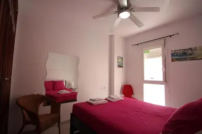 a bedroom with a red bed and a window at Apartamento VELADOR del Sur by Cadiz4Rentals in Cádiz