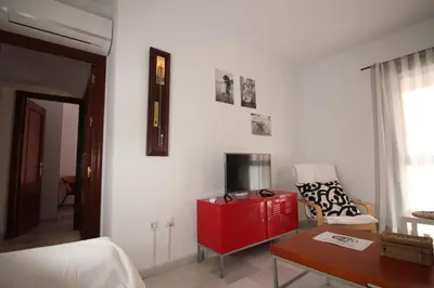 a living room with a red cabinet and a tv at Apartamento VELADOR del Sur by Cadiz4Rentals in Cádiz