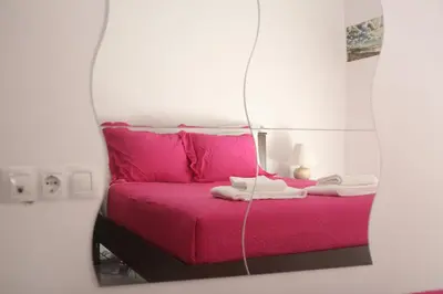 a bedroom with a pink bed in a mirror at Apartamento VELADOR del Sur by Cadiz4Rentals in Cádiz