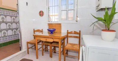 a kitchen with a table and chairs and a plant at APARTAMENTO VILLA DE ROTA - VISTA MAR, 135m2, Terraza, SAT TV y más in Rota