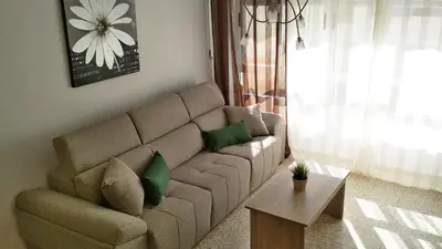 a living room with a brown couch with green pillows at APARTAMENTO VILLA DE ROTA - VISTA MAR, 135m2, Terraza, SAT TV y más in Rota