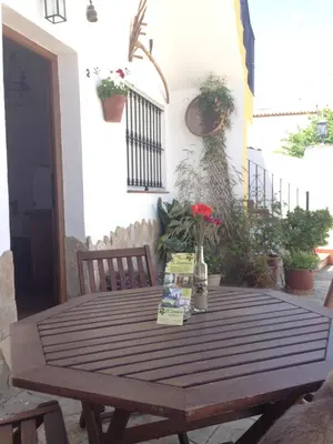 a wooden table with flowers on a patio at Casa Rural El Limonero in Los Naveros