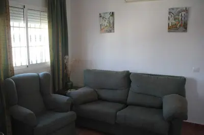 a living room with a couch and a chair at Casa Rural El Limonero in Los Naveros