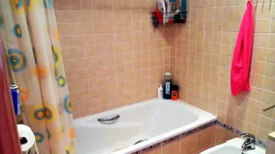 a bathroom with a bath tub with a pink shower curtain at Cadiz Golf in Sanlúcar de Barrameda