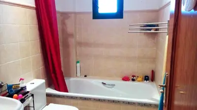 a bathroom with a tub and a red shower curtain at Cadiz Golf in Sanlúcar de Barrameda