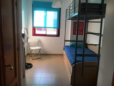a room with two bunk beds and a chair at Cadiz Golf in Sanlúcar de Barrameda
