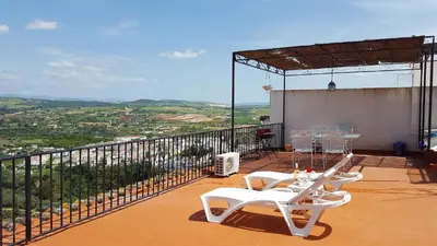 a balcony with two white chairs and a table at CASA RICARDO 