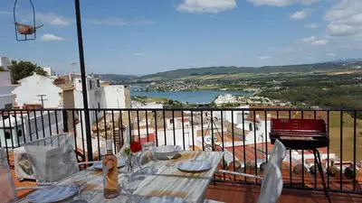 a table on a balcony with a view of a river at CASA RICARDO 