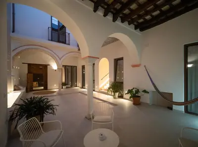 a large room with chairs and tables in a building at Apartamentos Alcoba 13 in Sanlúcar de Barrameda
