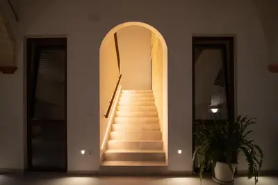 a hallway with a staircase with an archway at Apartamentos Alcoba 13 in Sanlúcar de Barrameda