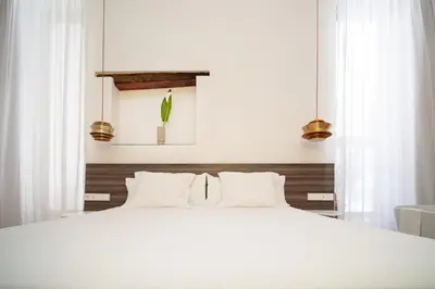 a bedroom with a white bed with white pillows at Apartamentos Alcoba 13 in Sanlúcar de Barrameda