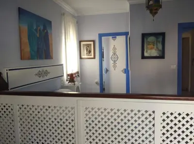 a hallway with a white fence and a blue door at El apartaito in Sanlúcar de Barrameda