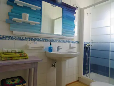 a bathroom with a sink and a mirror and a shower at El apartaito in Sanlúcar de Barrameda