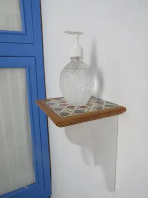 a glass vase on a wooden shelf next to a door at El apartaito in Sanlúcar de Barrameda