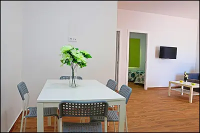a dining room with a table with a vase of flowers on it at Casa Rural Zara II in Conil de la Frontera