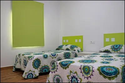 two beds in a room with green and white at Casa Rural Zara II in Conil de la Frontera