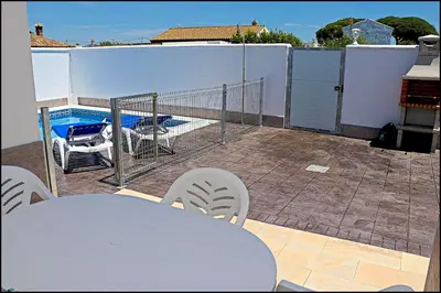 a table and chairs on a balcony with a pool at Casa Rural Zara II in Conil de la Frontera