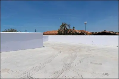 a white wall on top of a parking lot at Casa Rural Zara I in Conil de la Frontera