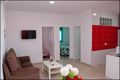 a living room with a couch and a red wall at Casa Rural Zara I in Conil de la Frontera