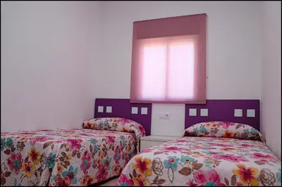 a bedroom with two beds and a window at Casa Rural Zara I in Conil de la Frontera