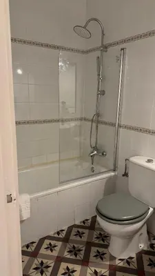 a bathroom with a shower and a toilet and a tub at Hostal Playa Hidalgo in Rota