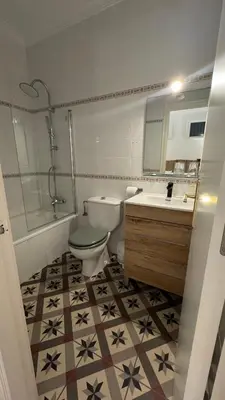 a bathroom with a toilet and a sink and a mirror at Hostal Playa Hidalgo in Rota