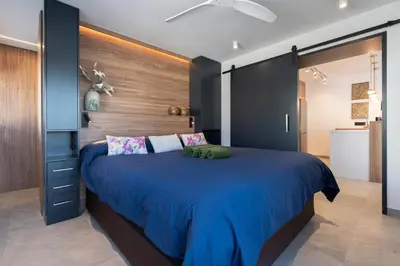 a bedroom with a large blue bed with a wooden wall at Ático Plata in Cádiz