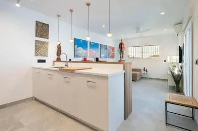a kitchen with white cabinets and a counter top at Ático Plata in Cádiz