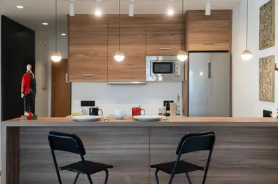 a kitchen with two chairs and a bar with a counter top at Ático Plata in Cádiz