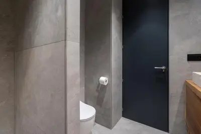 a bathroom with a toilet and a glass door at Ático Plata in Cádiz