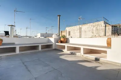two benches sitting on the side of a building at Ático Plata in Cádiz
