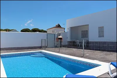 a swimming pool in front of a white building at Casa Rural Zara III in Conil de la Frontera