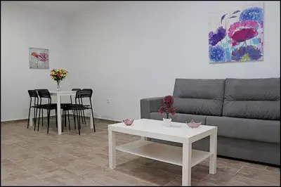 a living room with a couch and tables and chairs at Casa Rural Zara III in Conil de la Frontera
