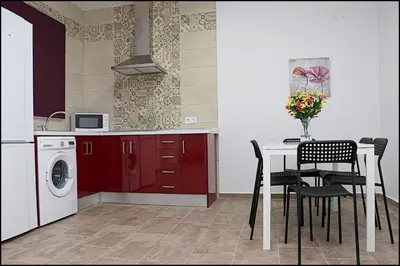 a kitchen with a table and a washing machine at Casa Rural Zara III in Conil de la Frontera