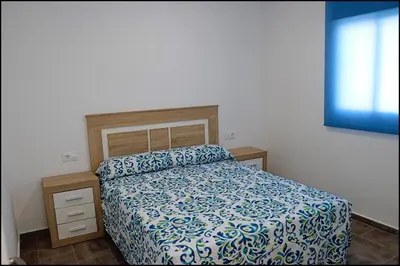 a bedroom with a bed with a blue and white bedspread at Casa Rural Zara III in Conil de la Frontera