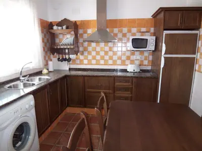 a kitchen with a sink and a table with a washing machine at Casa Jorge in Conil de la Frontera