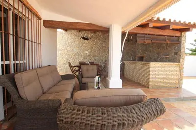 a patio with a couch and chairs and a fireplace at Casa Jorge in Conil de la Frontera