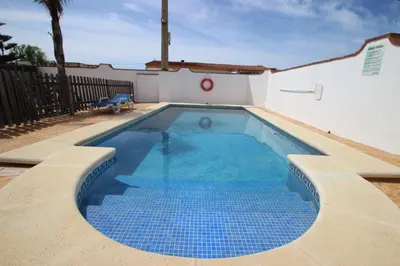 a small swimming pool with blue tiles in a yard at Casa Jorge in Conil de la Frontera