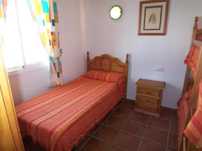 a small bedroom with a bed and a window at Casa Jorge in Conil de la Frontera