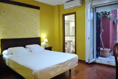 a bedroom with a large white bed and a window at Hostal La Andaluza in San Fernando