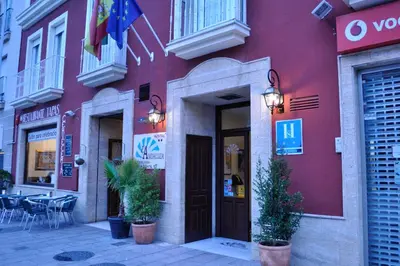 a red building with plants in front of it at Hostal La Andaluza in San Fernando